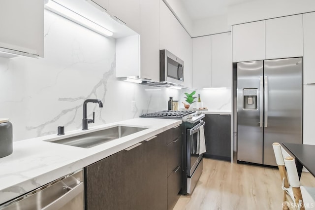 kitchen featuring appliances with stainless steel finishes, dark brown cabinets, sink, and white cabinets