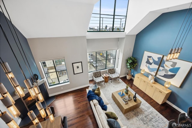 living room featuring a high ceiling and dark hardwood / wood-style flooring