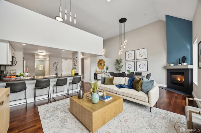 living room featuring sink, hardwood / wood-style flooring, and high vaulted ceiling