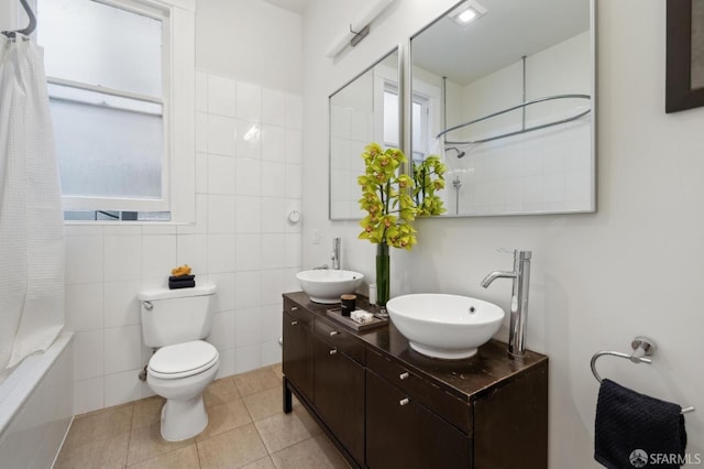 full bath featuring double vanity, a sink, shower / bathtub combination with curtain, and tile patterned floors