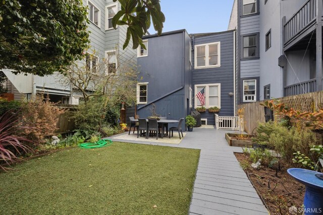 back of property featuring a patio area and a yard