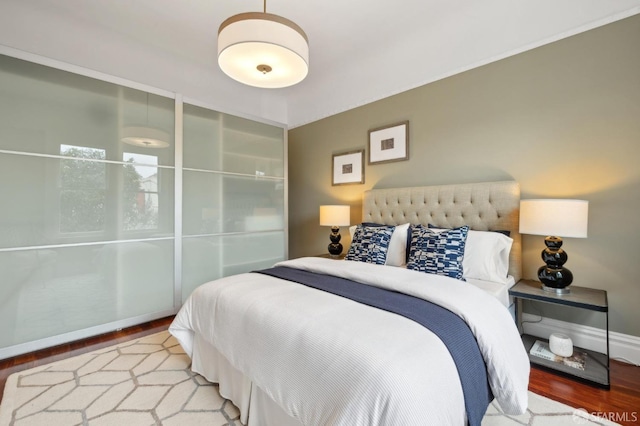 bedroom featuring wood finished floors and baseboards