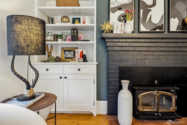 room details with hardwood / wood-style flooring, a wood stove, and built in features