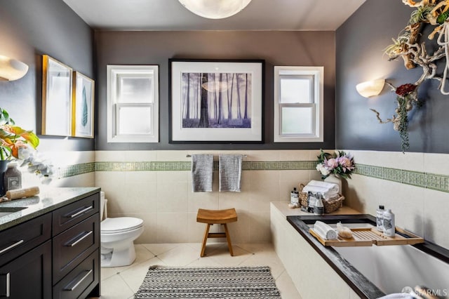 bathroom featuring tile walls, vanity, tile patterned floors, and toilet