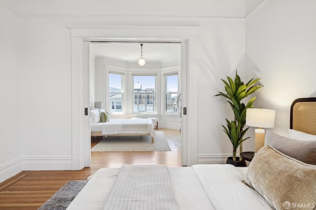 bedroom with baseboards and wood finished floors