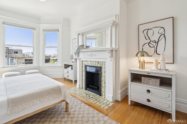 bedroom with a fireplace and wood finished floors