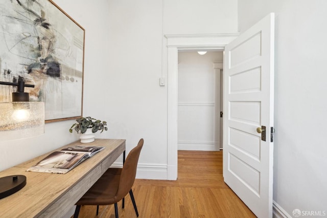 home office with light wood-type flooring and baseboards