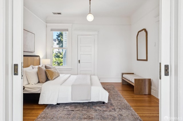 bedroom featuring baseboards, visible vents, and wood finished floors