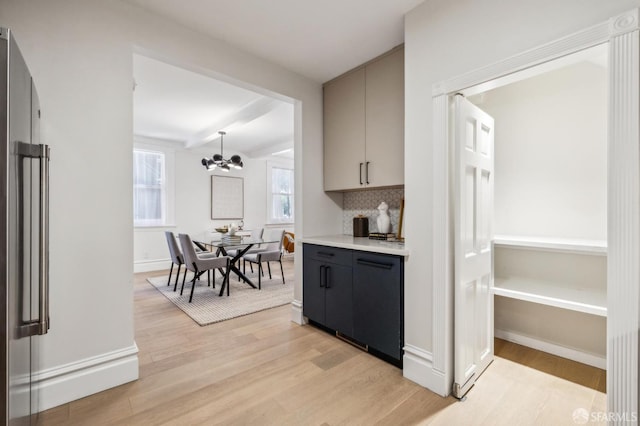 835 Diamond St, San Francisco, CA 94114 - kitchen with stainless steel refrigerator, light wood-style floors, gray cabinetry, a chandelier, and backsplash