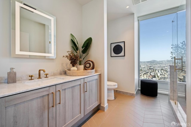 401 Harrison St Unit 45C, San Francisco, CA 94105 - bathroom with vanity, toilet, tile patterned flooring, baseboards, and a mountain view