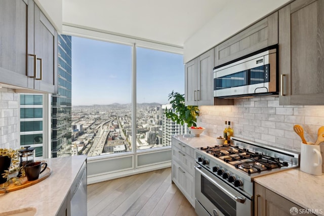401 Harrison St Unit 45C, San Francisco, CA 94105 - kitchen featuring stainless steel appliances, backsplash, light wood-style flooring, and light stone countertops