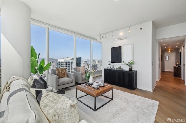 401 Harrison St Unit 45C, San Francisco, CA 94105 - living room with wood finished floors, rail lighting, a city view, baseboards, and a wall of windows