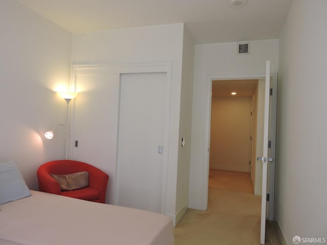 bedroom with light carpet and a closet