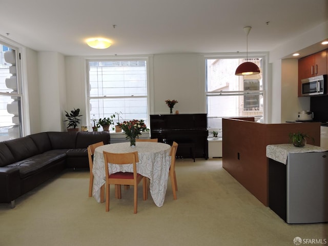 dining space with light colored carpet and a wealth of natural light