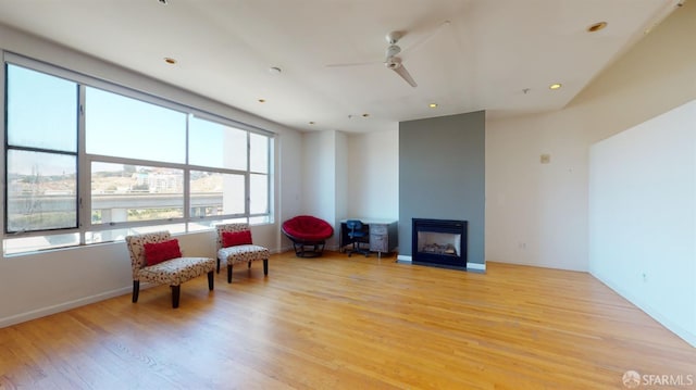 living area with light hardwood / wood-style flooring and ceiling fan