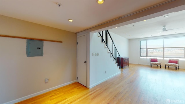 interior space with light hardwood / wood-style floors, electric panel, and ceiling fan