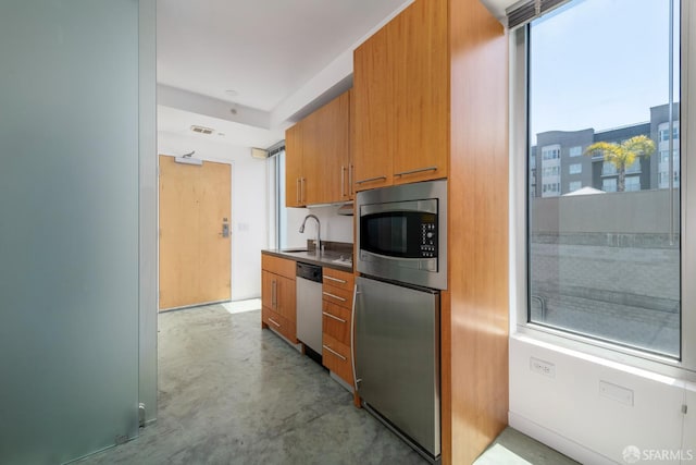 766 Harrison St Unit 403, San Francisco, CA 94107 - kitchen featuring appliances with stainless steel finishes, finished concrete floors, brown cabinets, and dark countertops