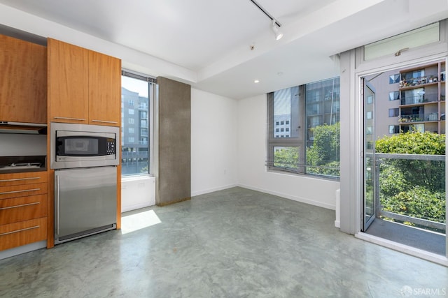 766 Harrison St Unit 403, San Francisco, CA 94107 - kitchen featuring stainless steel microwave, track lighting, concrete floors, and healthy amount of natural light