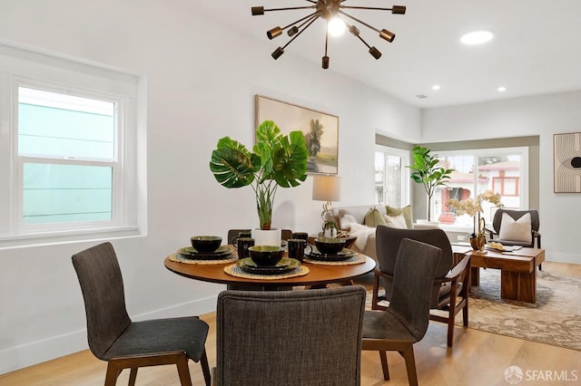 dining room with a chandelier, light wood-type flooring, and a healthy amount of sunlight