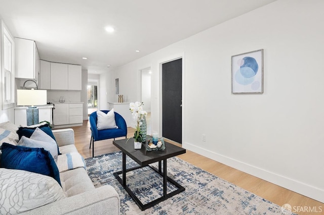 living room with sink and light hardwood / wood-style floors