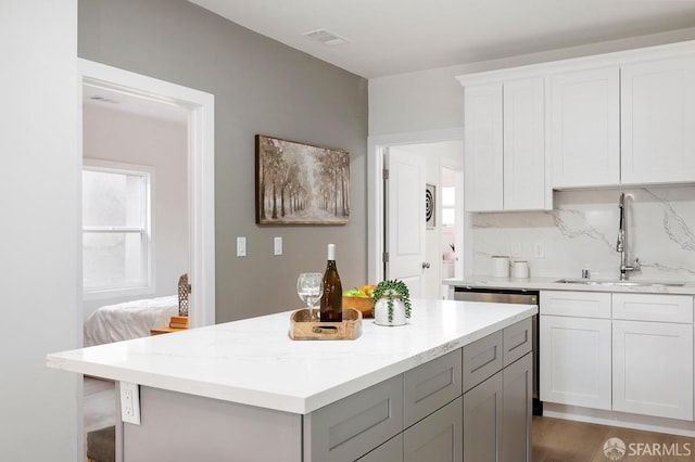 kitchen featuring white cabinetry, sink, tasteful backsplash, light stone counters, and dark hardwood / wood-style flooring