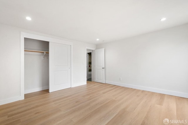 unfurnished bedroom featuring light hardwood / wood-style flooring and a closet