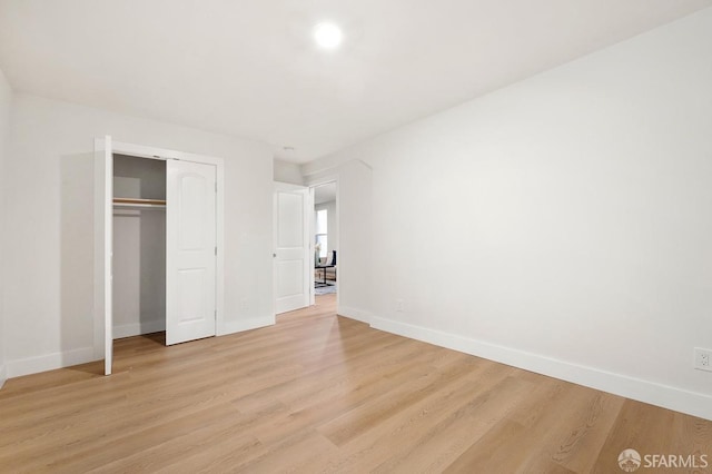 unfurnished bedroom featuring light wood-type flooring and a closet