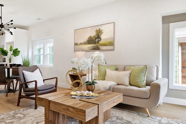 sitting room featuring a healthy amount of sunlight, light wood-type flooring, and a chandelier