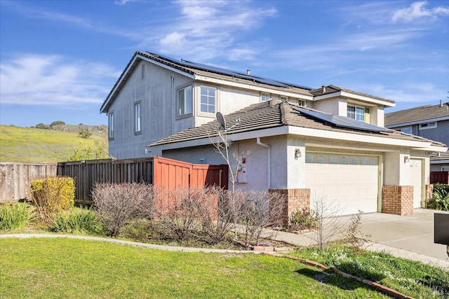 front facade featuring a garage, a front lawn, and solar panels