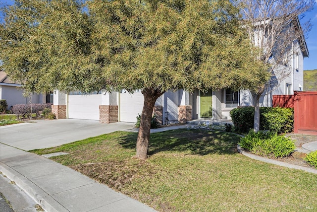 view of property hidden behind natural elements with a garage and a front yard