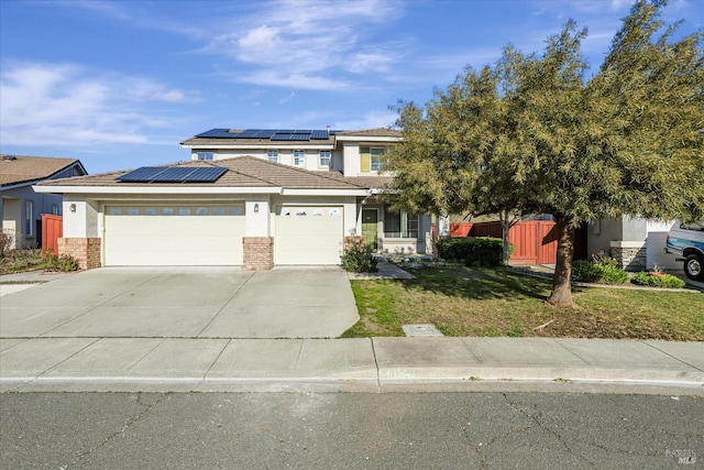 view of front of house with a garage, a front lawn, and solar panels