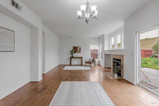 interior space with wood-type flooring, a fireplace, visible vents, and baseboards