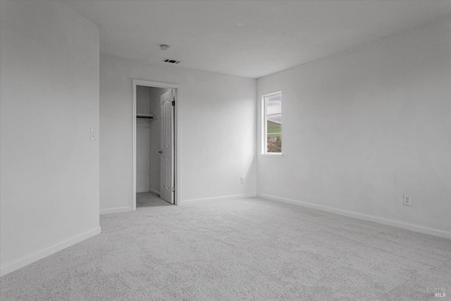 unfurnished room featuring baseboards, visible vents, and carpet flooring