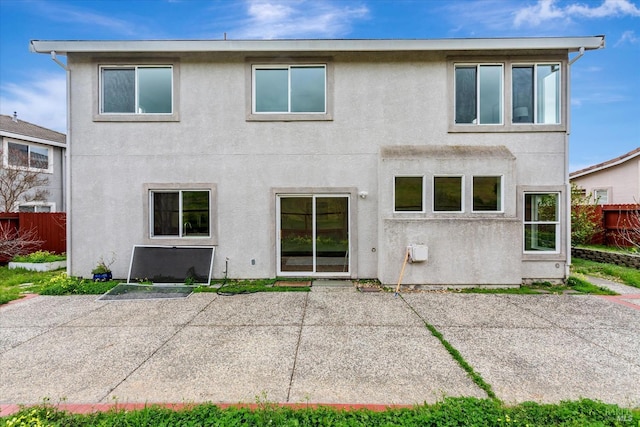 back of property featuring fence, a patio, and stucco siding