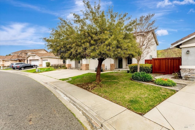 obstructed view of property featuring a front yard, fence, a garage, a residential view, and driveway