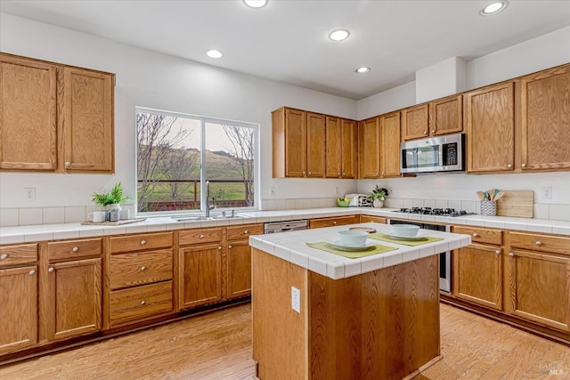 kitchen with dishwasher, stainless steel microwave, recessed lighting, and light wood-style floors