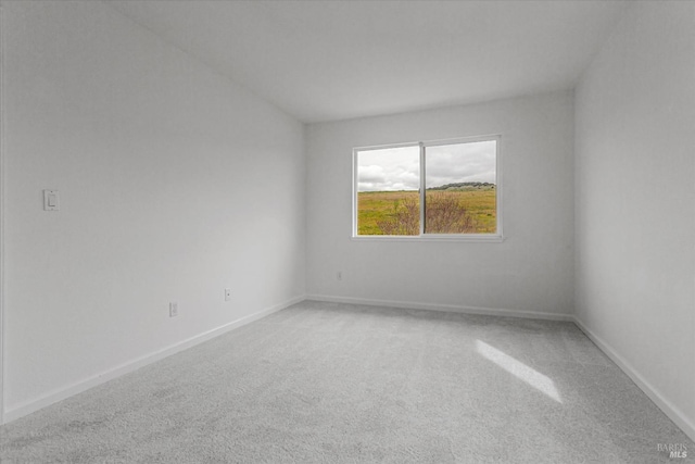 empty room with light colored carpet and baseboards