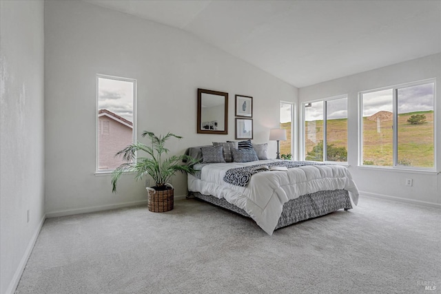 bedroom with vaulted ceiling, multiple windows, and carpet flooring