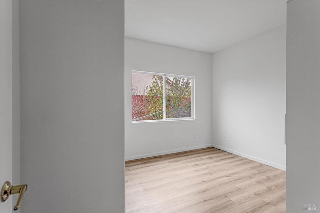 unfurnished room with baseboards and wood finished floors