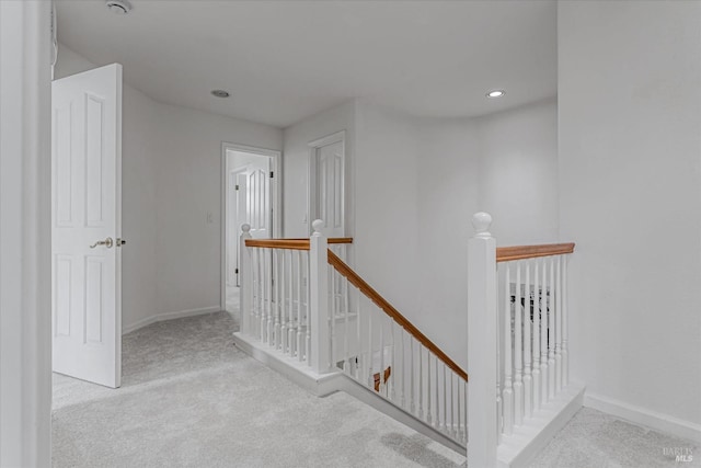 hallway featuring recessed lighting, carpet, baseboards, and an upstairs landing