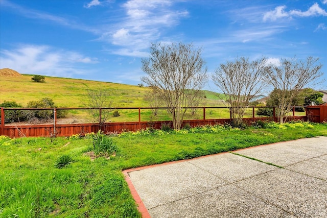 view of yard with fence and a rural view