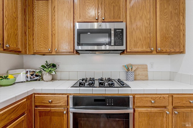 kitchen with light countertops, appliances with stainless steel finishes, and brown cabinetry