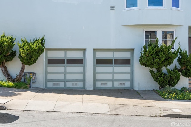 garage with visible vents and driveway