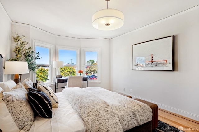 bedroom featuring multiple windows, wood finished floors, and crown molding