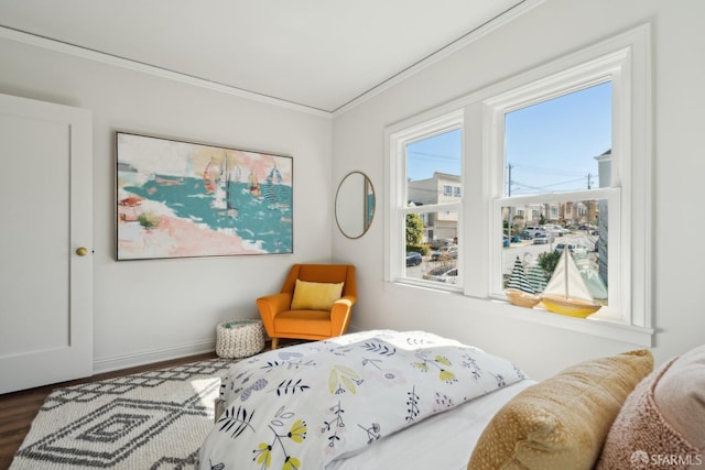 bedroom with wood finished floors, baseboards, and ornamental molding