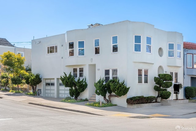 view of front of house featuring stucco siding, concrete driveway, and an attached garage