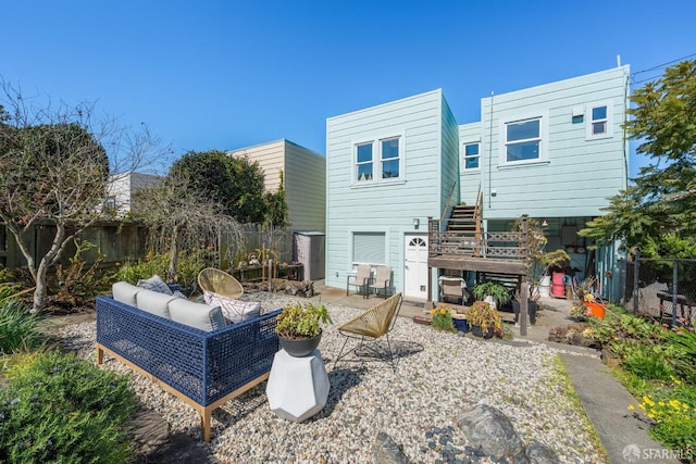 rear view of house featuring a patio area, stairway, an outdoor living space, and fence