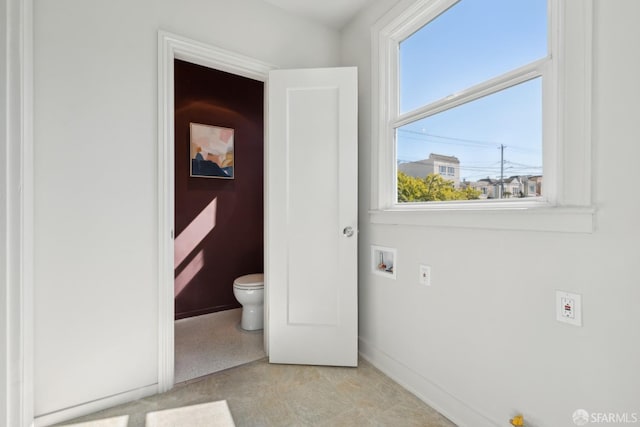 bathroom with toilet and baseboards