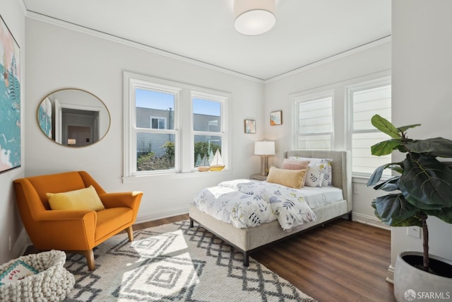 bedroom featuring ornamental molding, baseboards, and wood finished floors