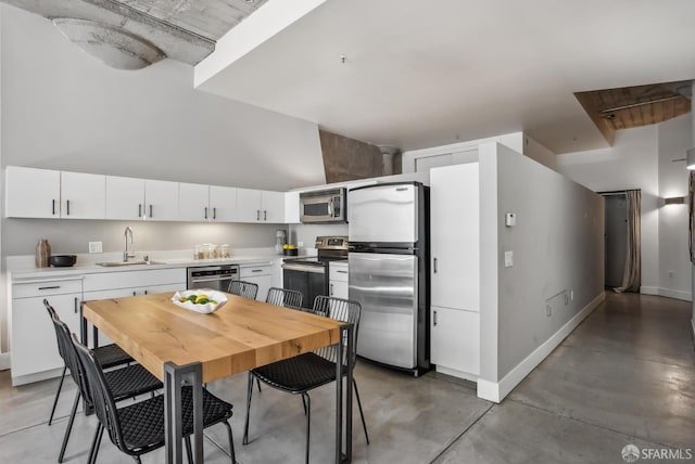 300 Beale St Unit 504, San Francisco, CA 94105 - kitchen with stainless steel appliances, a sink, concrete floors, light countertops, and white cabinetry